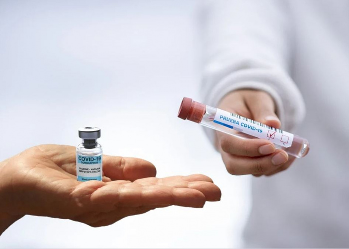 баночки с вакциной в руках врачей